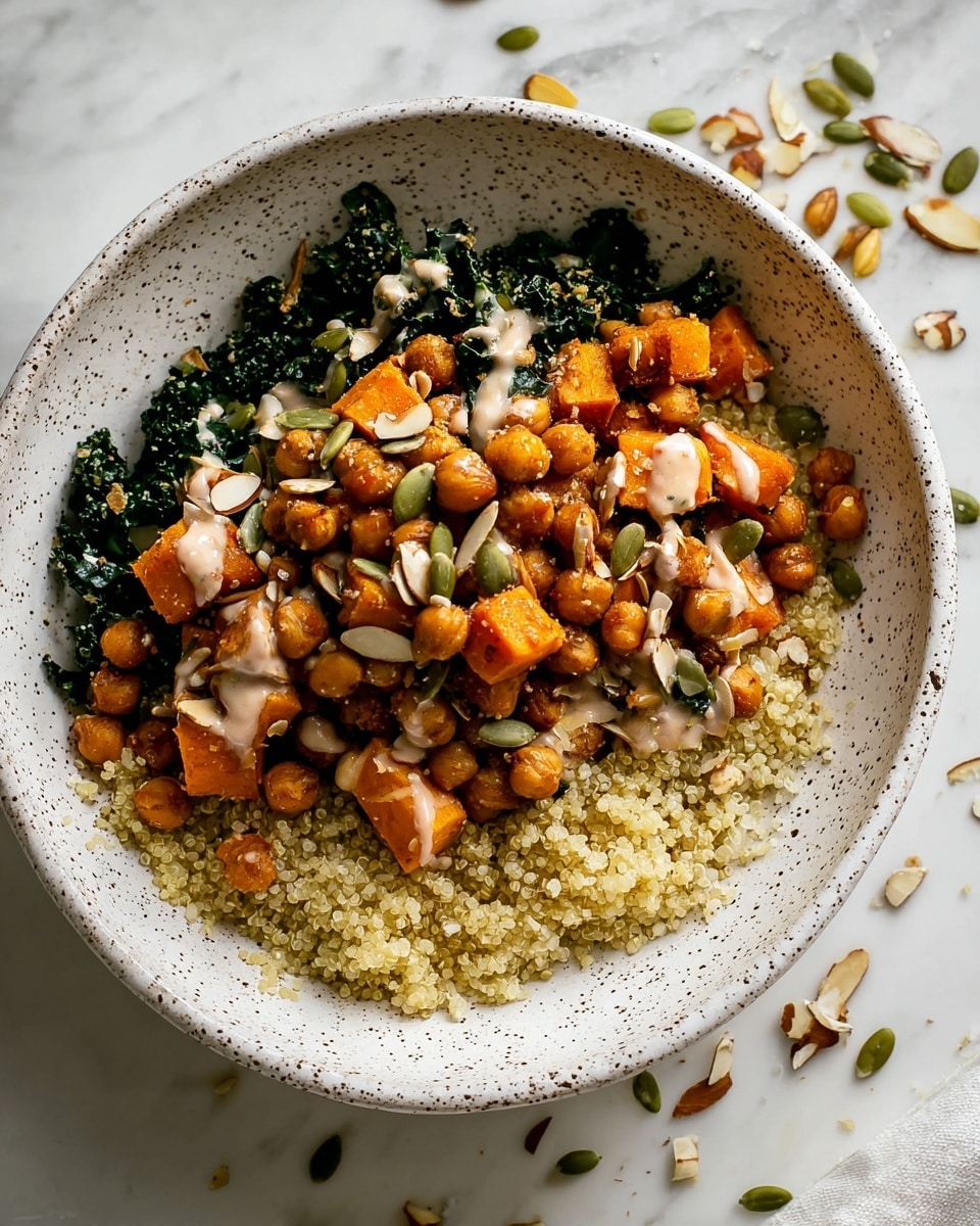 A white speckled bowl filled with three visible layers: the bottom layer is dark green chopped kale arranged around the edges, the middle layer is a fluffy pale yellow quinoa spread mostly in the center, and the top layer consists of golden-brown roasted chickpeas mixed with slightly larger cubes of roasted orange sweet potatoes, all drizzled with a light creamy sauce and sprinkled with green pumpkin seeds and a few almond slices. The bowl sits on a white marbled surface with some scattered seeds around. Photo taken with an iphone --ar 4:5 --v 7