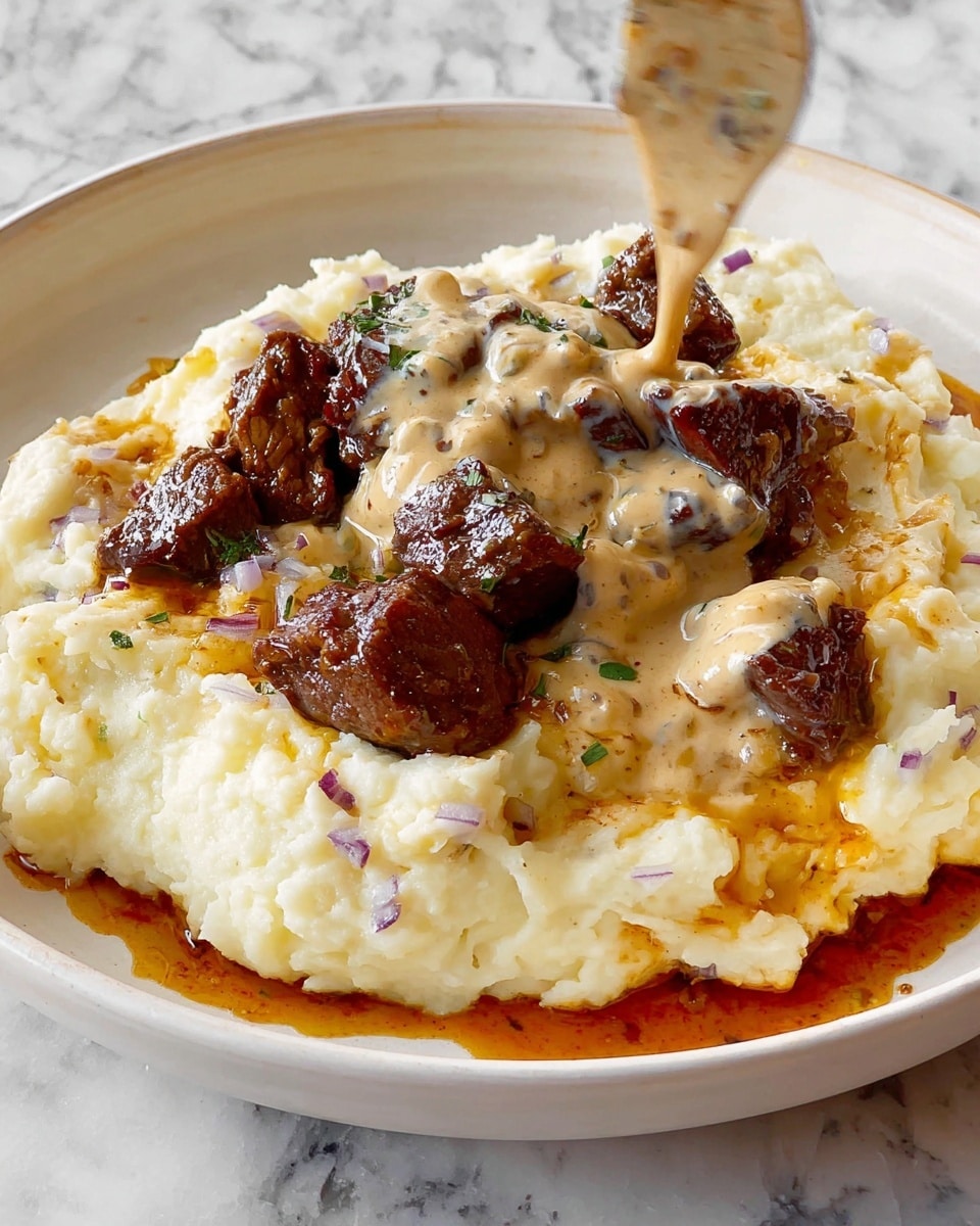 The dish shows a white plate with three layers: the bottom layer is creamy mashed potatoes with small bits of red skin visible, giving it a textured and soft look; the middle layer has dark brown, seared meat pieces that look juicy with a slightly crispy outer crust; the top layer features a light beige creamy sauce being drizzled over the meat, with hints of herbs and a smooth, thick texture; there is a reddish-brown oily sauce pooling slightly around the mashed potatoes on the plate edges. The background is a white marbled texture. Photo taken with an iphone --ar 4:5 --v 7