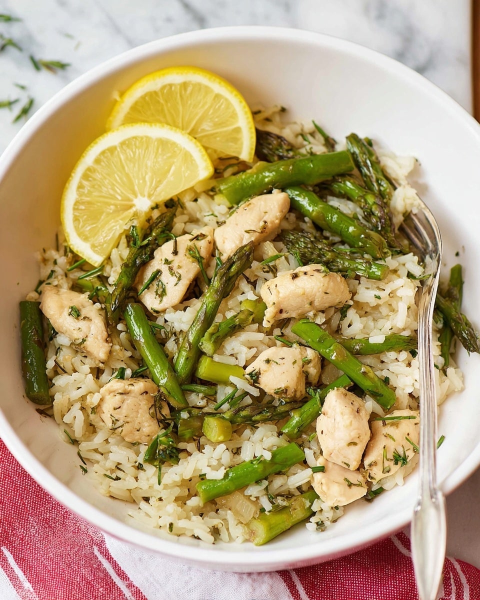 A white bowl holds a dish with three main layers: at the bottom is a mix of white rice grains, scattered with green asparagus pieces cut into small and medium lengths, and light brown cooked chicken chunks sprinkled with finely chopped green herbs and black pepper. On top, two thin yellow lemon slices are placed slightly overlapping near the edge of the bowl. A silver fork rests inside the bowl, touching the rice and chicken mixture. The bowl sits on a white marbled surface with a part of a red and white striped cloth nearby. Photo taken with an iphone --ar 4:5 --v 7