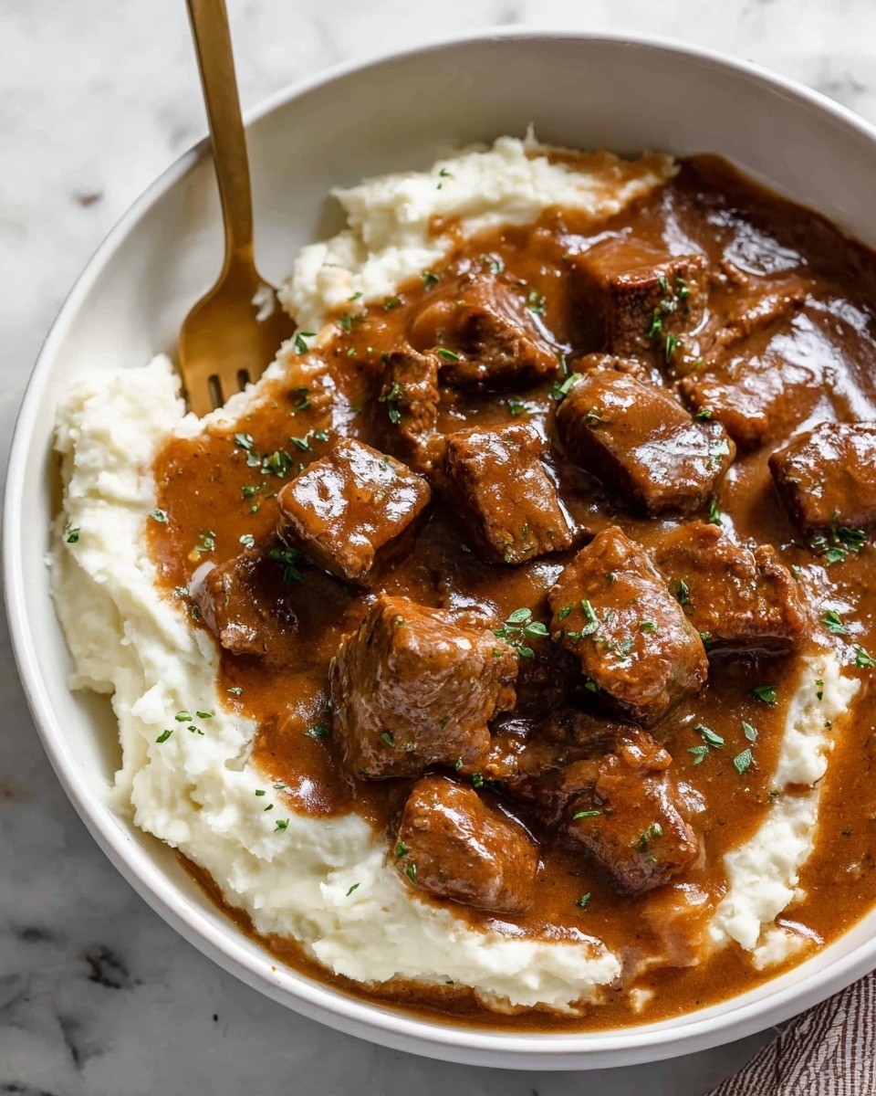 The image shows a white pot filled with rich brown beef stew, with visible chunks of tender meat coated in thick sauce. The stew is garnished with small green herb pieces sprinkled on top. A wooden spoon is partially submerged in the stew on the left side of the pot. The pot sits on a white marbled surface with small bowls around it, including one with green herbs and another with ground black pepper. A small part of creamy mashed potatoes in a white bowl is visible at the top left corner. Photo taken with an iphone --ar 4:5 --v 7