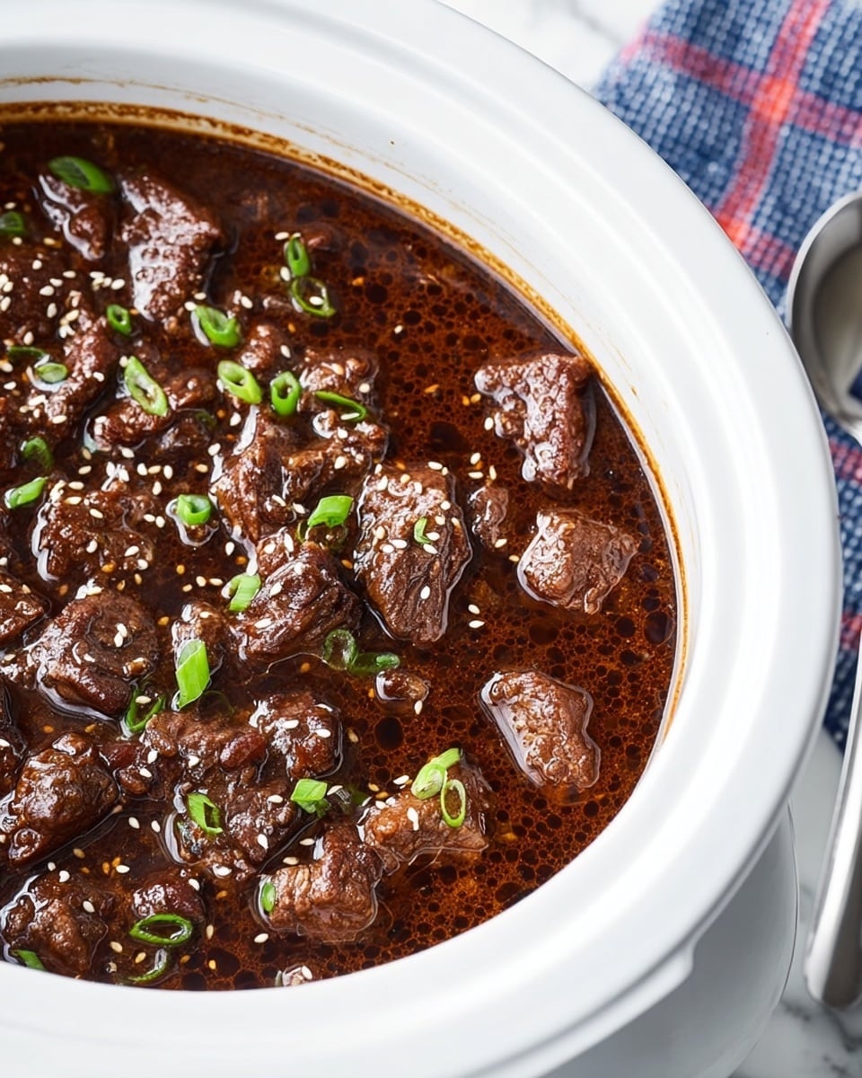 A close-up view of slow-cooked beef stew inside a white slow cooker, showing chunks of dark brown tender beef submerged in glossy, rich brown sauce with small bubbles on the surface. The stew is topped with small green onion pieces and scattered white sesame seeds that add texture and color contrast. The slow cooker sits on a white marbled surface with a folded blue and red checkered cloth and a silver spoon next to it. Photo taken with an iphone --ar 4:5 --v 7