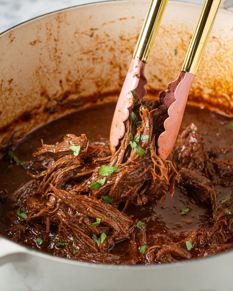 The image shows shredded, cooked beef soaked in dark brown sauce with small green herb pieces sprinkled on top. The beef appears soft and tender, with visible stringy textures and a glossy surface from the sauce. Pink silicone tongs with gold handles are holding some strands of the beef, positioned over a white pot with sauce splattered inside its rim. The background features a white marbled texture. photo taken with an iphone --ar 4:5 --v 7